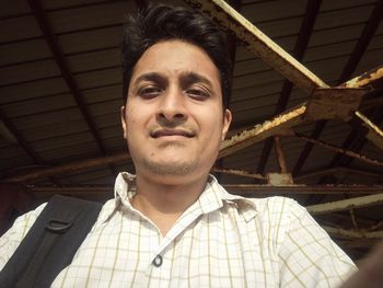 Low angle view of young man under shed