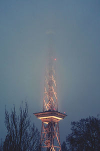 Low angle view of illuminated tower against sky at dusk