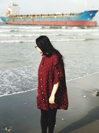 Woman looking at sea while standing on beach