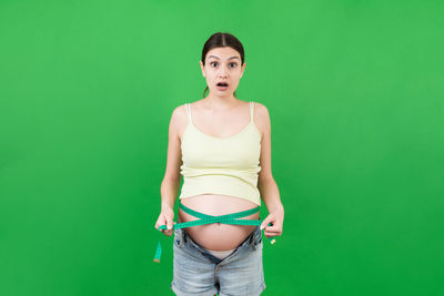 Portrait of a beautiful young woman over green background