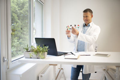 Doctor holding molecular structure at clinic