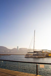 Sailboats in sea against clear sky