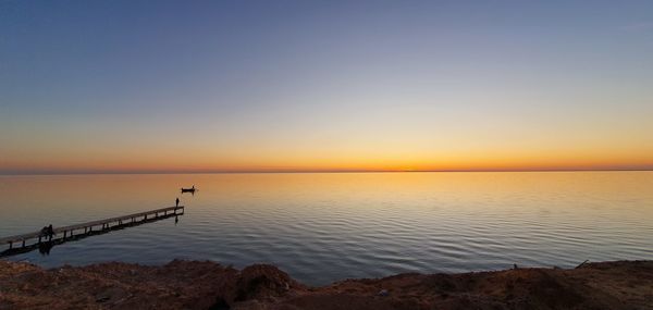 Scenic view of sea against clear sky during sunset