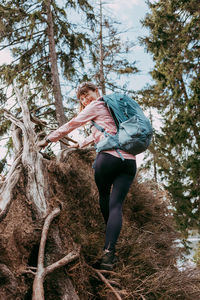 Portrait of a young woman with a backpack in the spring forest. sports activity in nature, hiking