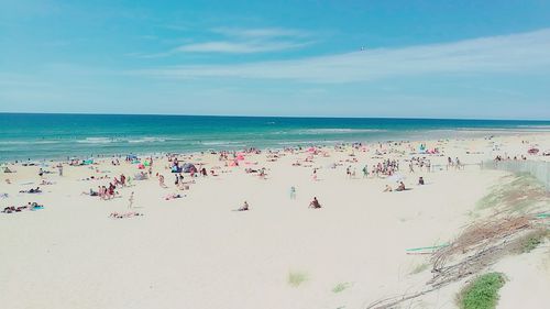 Panoramic view of people on beach against sky