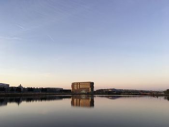 Reflection of building in lake during sunset