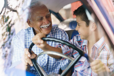 Man smiling woman with umbrella while sitting in car