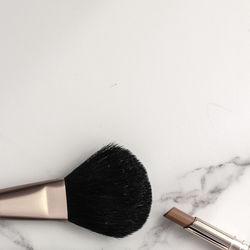 High angle view of make-up brushes over white background