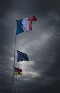 Low angle view of flags against sky