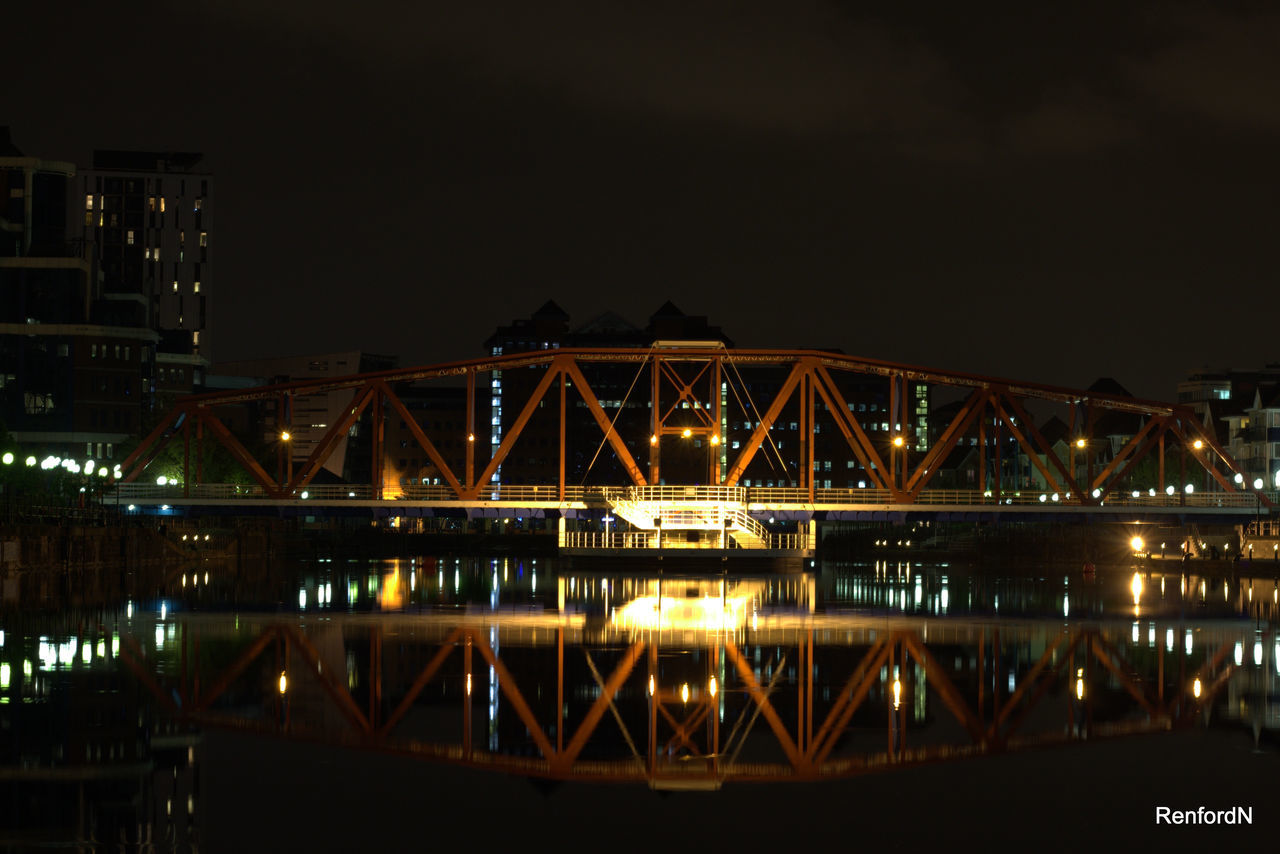 SUSPENSION BRIDGE OVER RIVER AT NIGHT