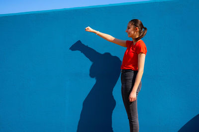 Full length of child standing by swimming pool against wall