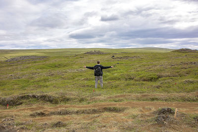 View of grassy field against cloudy sky