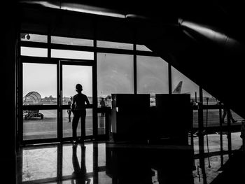 Rear view of boy standing at airport