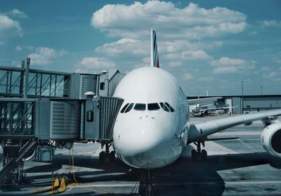 Airplane on airport runway against sky