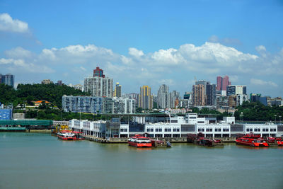 Boats in sea against buildings in city