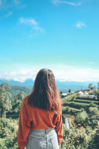 Rear view of man standing on landscape against sky