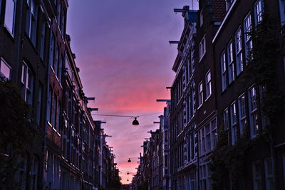 Low angle view of buildings against sky at sunset