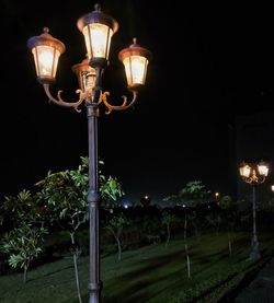 Low angle view of illuminated street light against sky at night