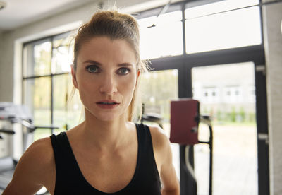 Close-up portrait of young woman in gym