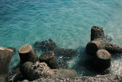 High angle view of rocks on sea shore