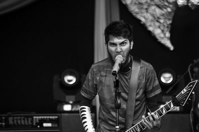 Portrait of man singing on stage at night