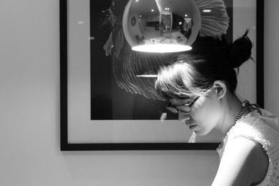 Woman with illuminated pendant light at home