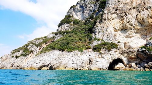 Rock formations by sea against sky