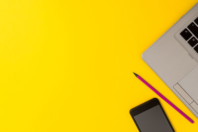 Close-up of airplane wing against yellow background