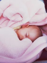 High angle view of newborn sleeping in pink blanket