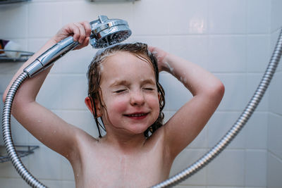 Close up of child washing hair in the shower