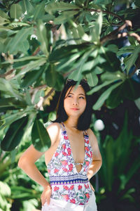 Portrait of woman standing against plants