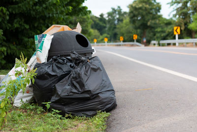 Garbage on road against trees in city