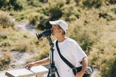 Man photographing while standing on camera
