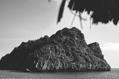 View of rock formation in sea against sky