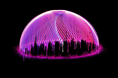 Illuminated ferris wheel against sky at night