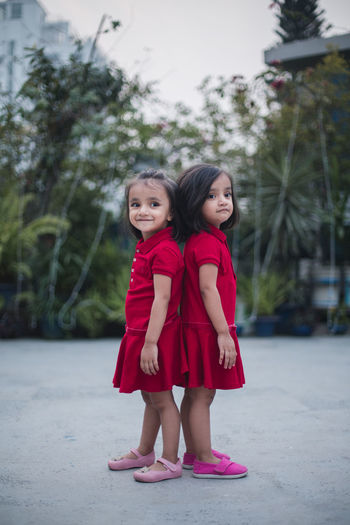 Twin sisters standing in backyard