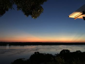 Scenic view of lake against sky at sunset