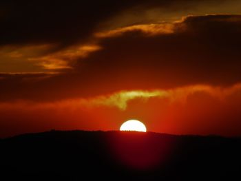 Scenic view of silhouette landscape against orange sky