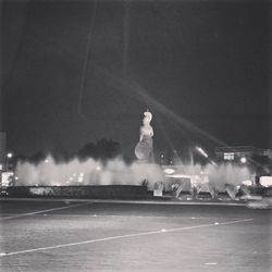 Man statue against illuminated sky at night