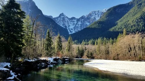 Scenic view of lake by mountains against sky