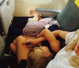 Cute girl sleeping on mother lap in airplane