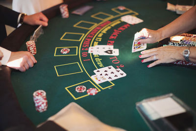 Cropped image of people playing poker