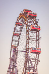 Low angle view of ferris wheel against clear blue sky