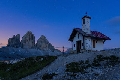 Gazebo by building against sky at night