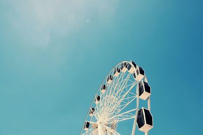 Low angle view of ferris wheel against blue sky