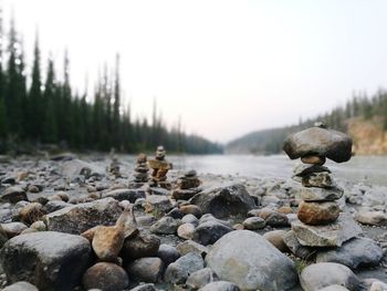 Stack of stones on shore against sky