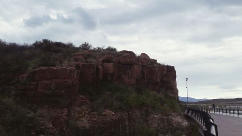 Bridge over rocks against sky