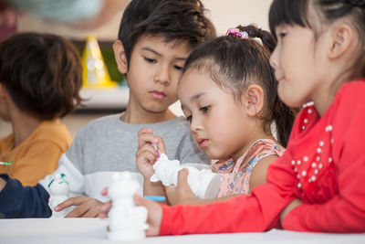 Students looking at toy in classroom