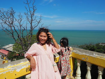 Woman standing by sea against sky