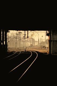 Railroad tracks against clear sky at night